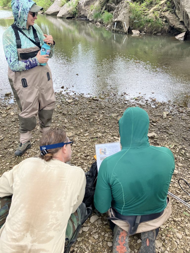 Watershed professionals reviewing field information beside a Kansas stream